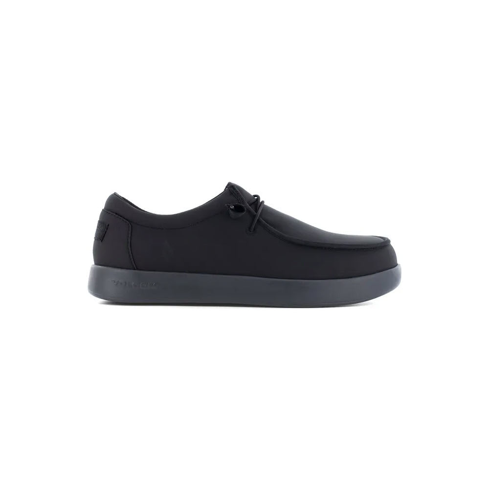 Image of a black, low-top casual shoe with a minimalist design and dark sole, shown in a side view. Perfect for those seeking the Volcom Composite Toe Chill Slip-On Work Shoe ESD in Black - Men&#39;s, this shoe offers both style and practicality.