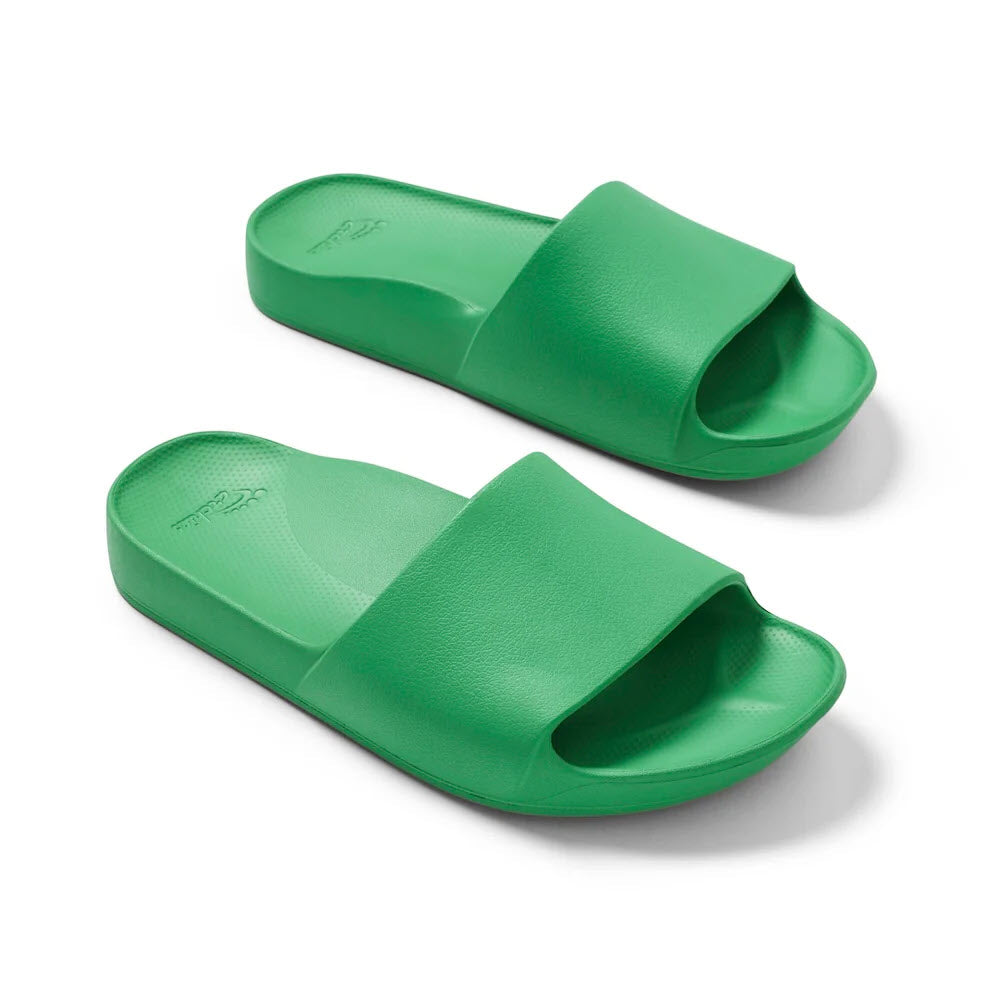 A pair of green ARCHIES SLIDES by Archies with a simple design, featuring a wide strap over the top and a flat sole, perfect for those seeking comfort and orthotic support.