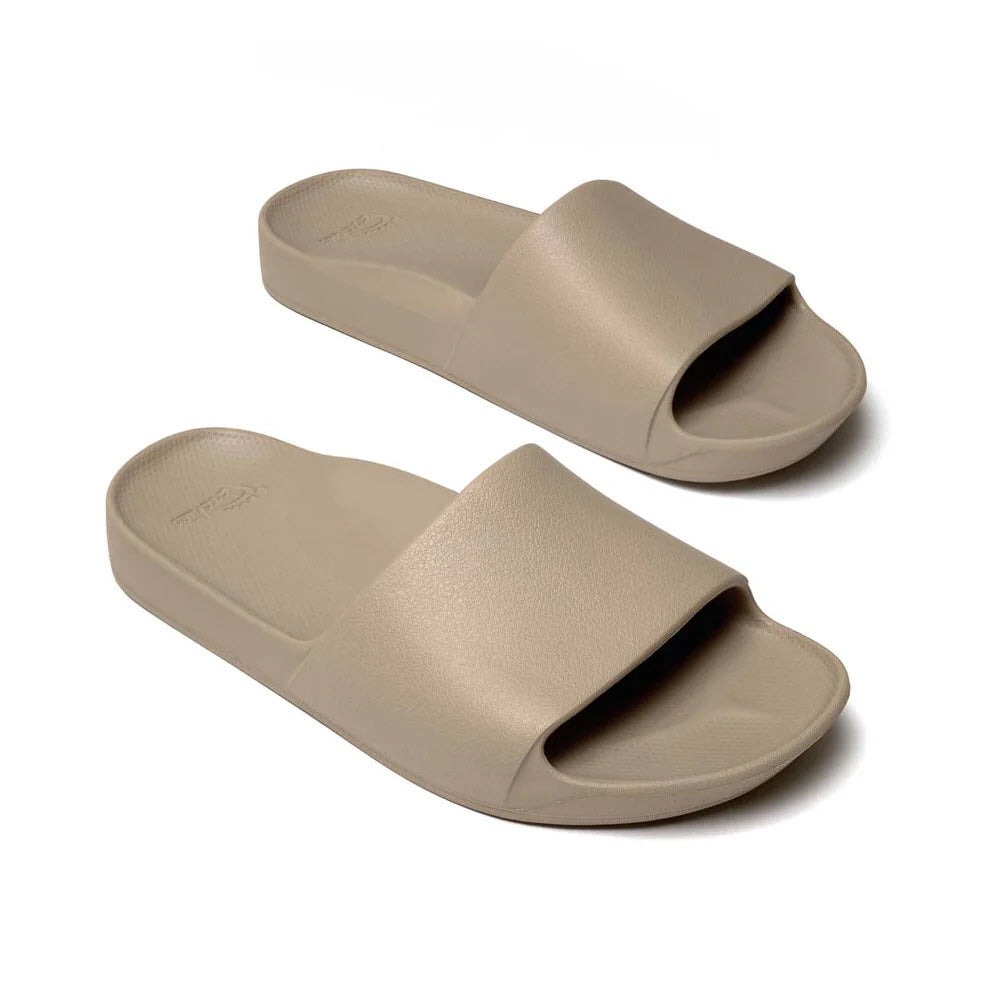 A pair of beige Archies ARCHIES SLIDES with a minimalist design and open-toe style, offering orthotic support for comfort and support.