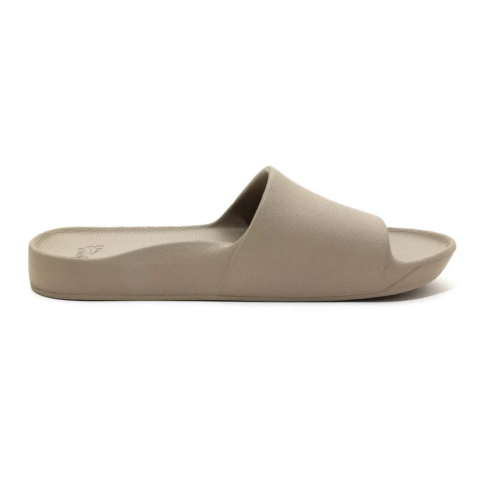 A single beige ARCHIES SLIDES sandal with an open-toe design and a flat sole, offering comfort and support for those with plantar fasciitis, by Archies.