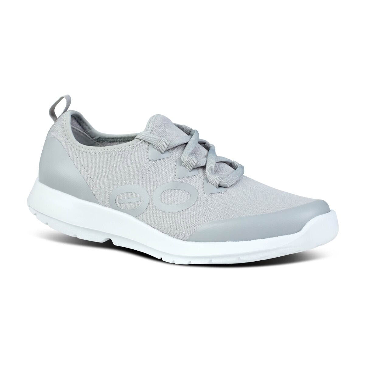 The OOFOS OOMG SPORT LS SLATE - WOMENS by Oofos is a light gray athletic shoe featuring a FibreFlex upper, white sole, lace-up closure, and a pull tab at the heel.