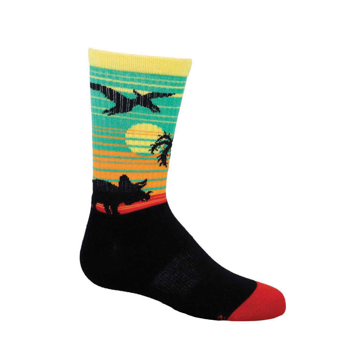 The Socksmith &quot;Dino Safari Crew Socks&quot; in teal for kids feature a vibrant pattern of dinosaurs, palm trees, and a sun on a gradient background of green, yellow, and orange. Perfect for little feet ready for giant adventures, these socks have red toes and heels with black soles and lower parts.