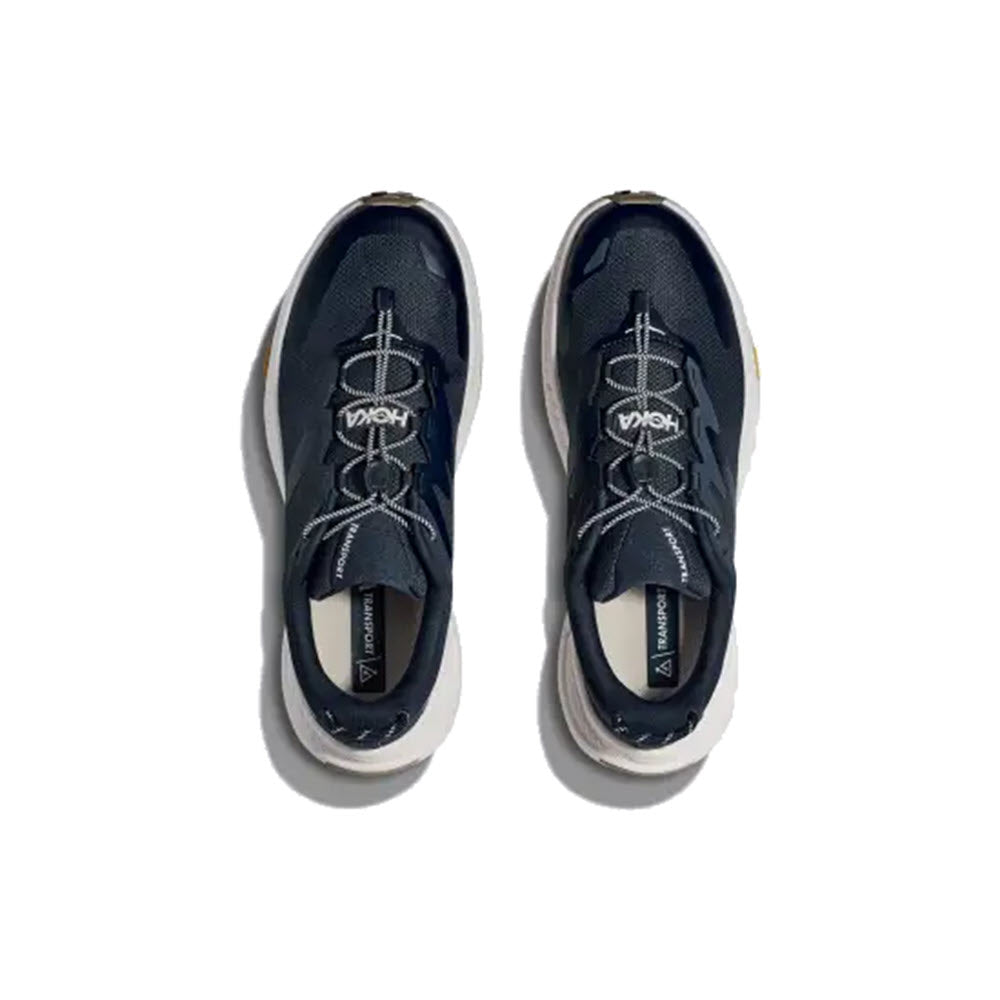 A pair of commuter-friendly HOKA Transport sneakers in navy with white soles, viewed from above, displayed against a plain white background.